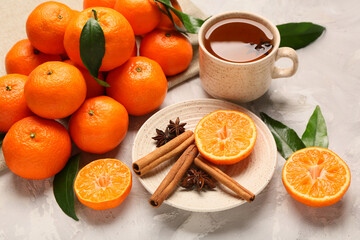 Sweet mandarins, cinnamon, star anise and cup of tea on grey background