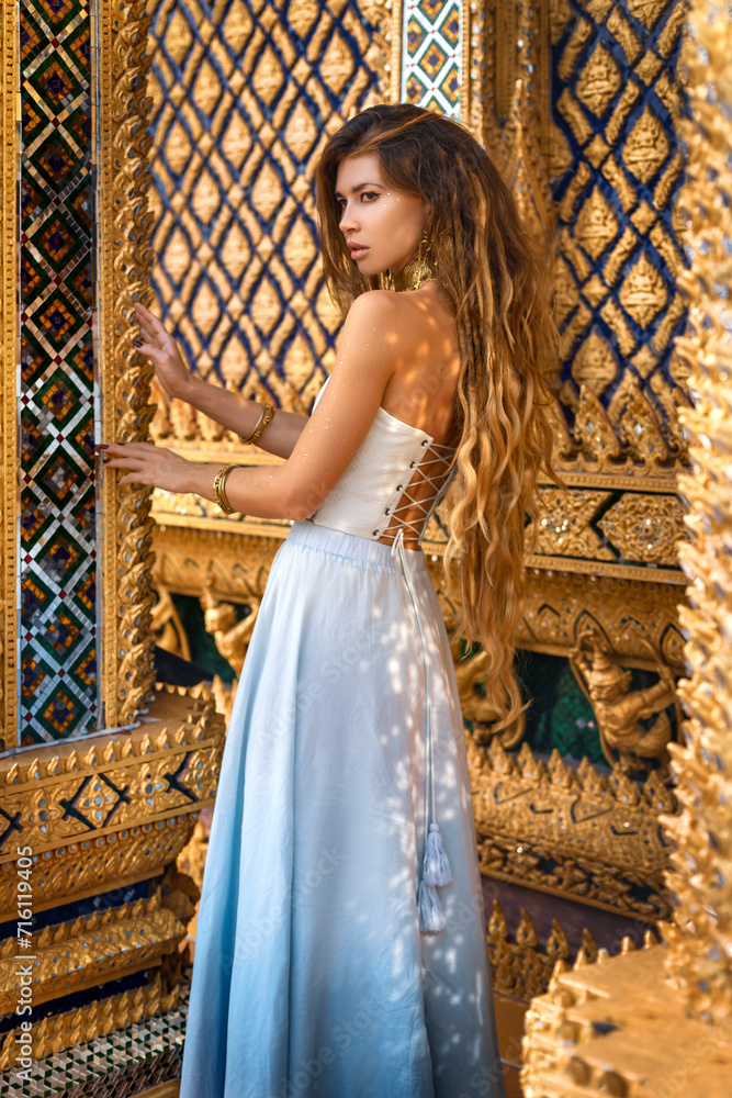 Wall mural beautiful young woman in elegant dress at asian temple