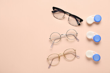 Stylish eyeglasses with containers for contact lenses on beige background