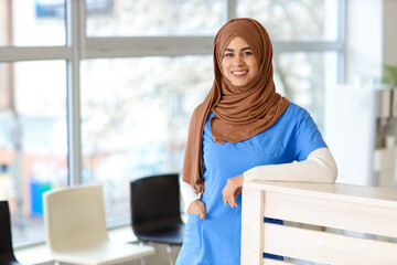 Female Muslim medical intern at reception in clinic