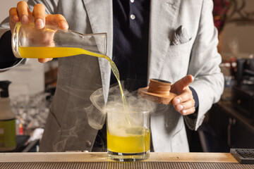 Bartender mixes drink with smoke