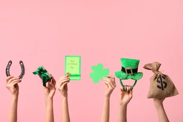 Foto op Plexiglas Female hands holding greeting card and party decor for St. Patrick's Day celebration on pink background © Pixel-Shot