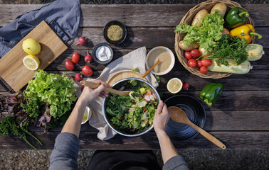 A woman enjoys a healthy salad at a restaurant during a delicious dinner, surrounded by a...