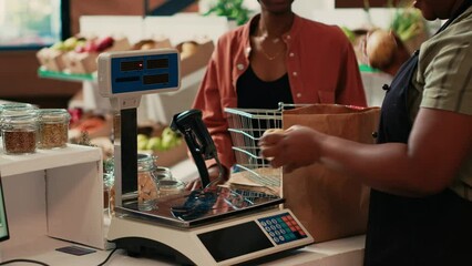 Grocery store owner weighting fruits and vegetables on scale to sell bulk food items to her customer, locally grown fresh produce. Woman supporting small business and sustainable lifestyle. - Powered by Adobe