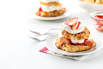 Servings of homemade mini strawberry shortcakes, against a bright background.