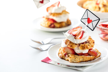 Mini strawberry shortcakes for Valentine's Day against a bright background.