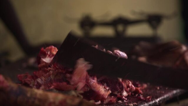 A market seller chops bones with a machete