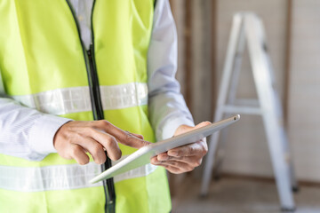 inspector or engineer is inspecting construction and quality assurance new house using a tablet....