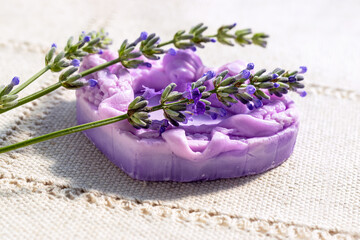 Bar of lavender-colored soap in shape of heart. Handmade. And sprigs of lavender. Lavandula angustifolia.
