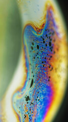 Fluid art. Paint swirl. Marble texture. Defocused orange blue pink color ink mix wave motion on dark green abstract art background.