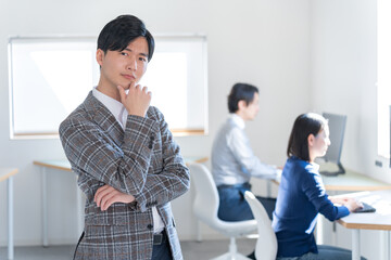 オフィスで考えるジャケットを着た若い日本人男性