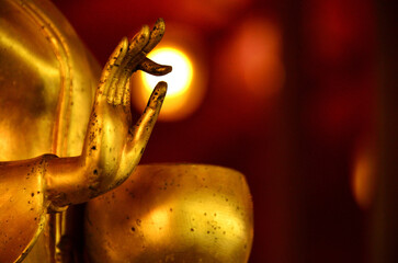 The hand of the Buddha image in the posture of holding an alms bowl. There is a golden small circle light between the fingers, look like  something miraculous happened.