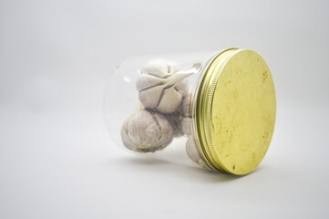 bunch of garlic in a plastic jar isolated on white background