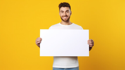 a handsome man holding a blank placard sign poster paper in his hands - obrazy, fototapety, plakaty