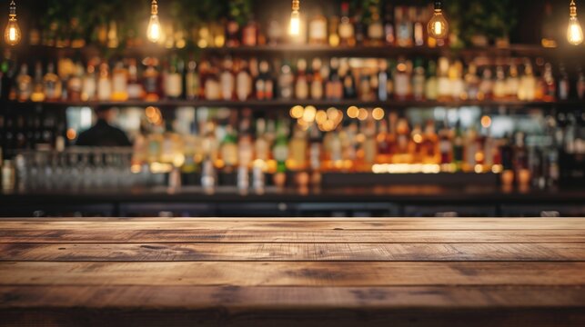 Wooden bar counter on a blurred background of bottles. Advertising space