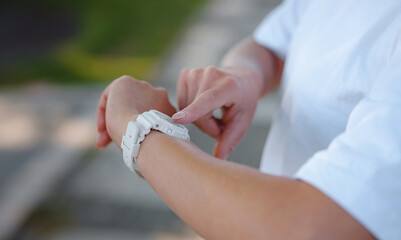 idea of healthy lifestyle and sports in modern city. Female jogger. Fit young Caucasian woman exercise looking for fitness bracelet. running routine or workout morning lifestyle in her application