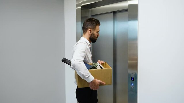 Dismissed worker with dismissal box getting into the elevator. Dismissal from work