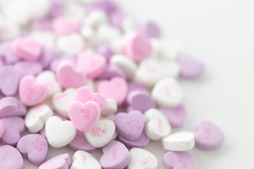 Obraz na płótnie Canvas Background for Valentine's Day. Assorted pink, purple, white heart shaped candies with printed messages of love. Messages about kisses. Gift for Women's Day, March 8
