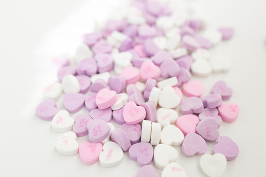 Background for Valentine's Day. Assorted pink, purple, white heart shaped candies with printed messages of love. Messages about kisses. Gift for Women's Day, March 8