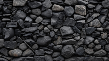 A textured black rock wall with scattered rocks
