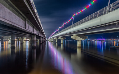 A view between the two road sections of the Sundale Bridge with lights and reflections at night on the Gold Coast in Queensland, Australia.