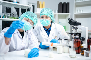 A Scientists or nutritionists are working on a sample of milk in biotechnology laboratory, genetic...