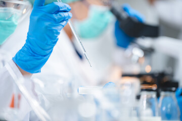 Close up of scientist or nutritionist dripping a sample of milk, fat or glucose in a test tube or...