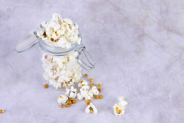 Obraz na płótnie Canvas Caramel sweet popcorn in glass jars, gray background, selective focus