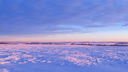 Winter snow hills in a field at sunset