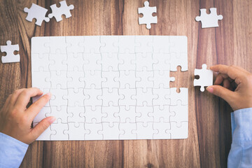  Hand of woman connecting jigsaw puzzle, Business solutions, success and strategy, Business partnership concept.