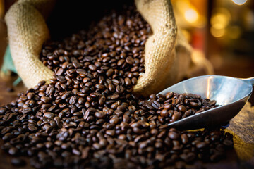 Naklejka premium Cup of coffee, bag and scoop on old wooden background, with copy space.