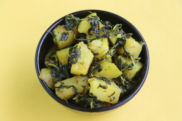 Aloo Palak sabzi, Spinach Potatoes dry curry served in a black bowl, Indian food