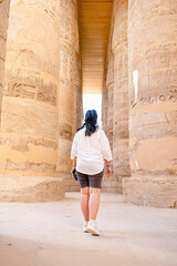 Fototapeta na wymiar Woman traveler explores the ruins of the ancient Karnak temple in the city of Luxor in Egypt.