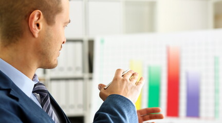 Man in suit point with arm in stats graph in office closeup. Stock exchange market advisor sale...