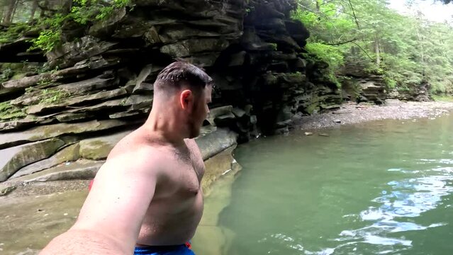man taking selfie when jumping to mountain creek river water
