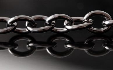 Silver chain with reflection on a black background