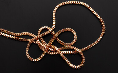 Gold chain isolated on black background. Close-up
