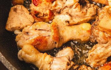 Chicken meat is stewed in a frying pan