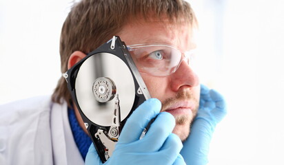 Repairman attached the hard drive of the computer to his ear. Listens to knock and crack reveals...