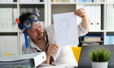 Man wearing suit and tie in goggles and snorkel hold in arm paper with big question sign at...