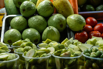 Fruit on display at a stall in a Vietnamese night market, with goji berries, mangoes and guavas.