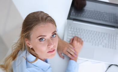 Beautiful smiling businesswoman portrait at workplace look in camera. White collar worker at...