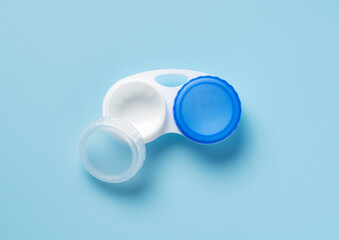 Case of contact lenses placed on a blue background. View from above.
