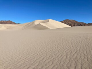 Fototapeta na wymiar Blue sky with rippled sand dunes