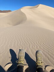 hiking boots in on rippled sand dune