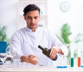 Male chemist examining wine samples at lab