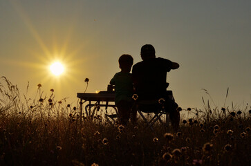 couple sitting on a bench at sunset