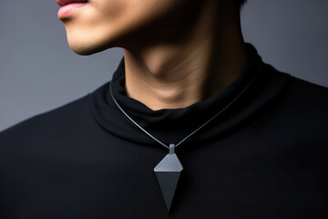 Photo of a man’s neck with a minimalist, geometrically shaped black obsidian necklace