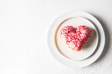 Fotobehang Heart shaped donut with pink glaze on white plate for Festive background oh Valentine day, Mother day, Birthday celebration © vasanty