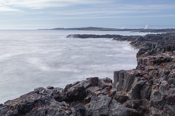 Fototapeta na wymiar South coast of Iceland: long exposure image of waves crashing on black basaltic volcanic cliffs